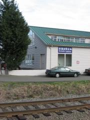 Modern white wooden building with track in foreground